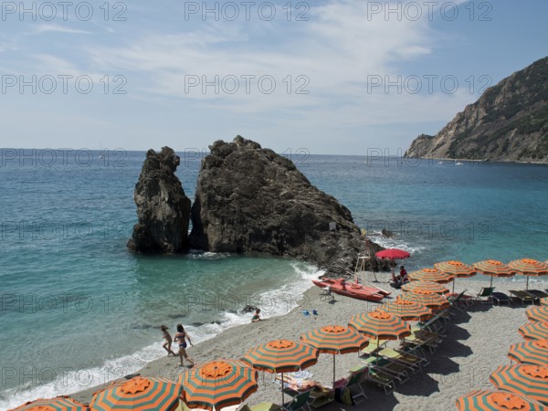 Beach with orange-green parasols, turquoise sea and rocks, Monte rosso, cinque terre, Italy, Europe
