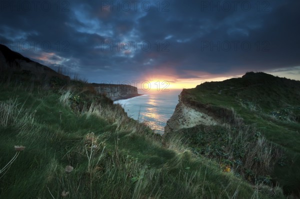 Sunset over cliffs in ocean, Etretat, France, Europe