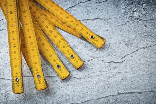 Wooden meter on metallic background top view construction concept