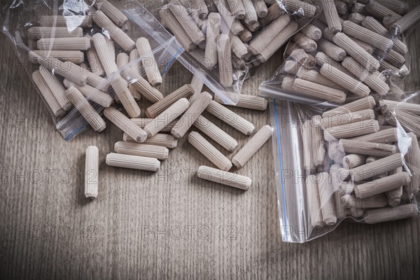 Wooden dowels on wood board close up view construction concept