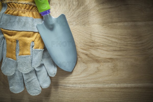 Gardening shovel safety gloves on wooden board
