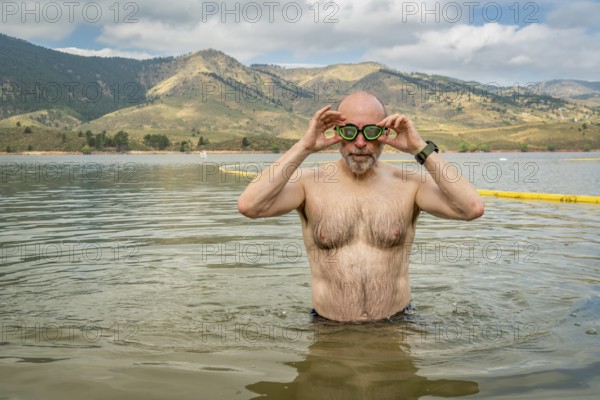 Active senior man finishing swimming workout in a mountain lake - Horsetooth Reservoir in northern Colorado