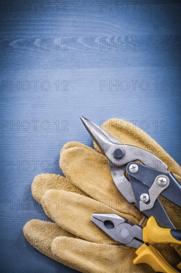 Pliers steel cutter pair of safety gloves on wooden board
