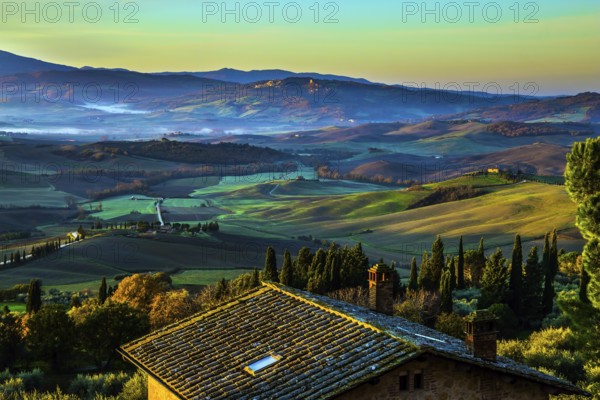 Predawn dusk. The sky is turning pink over the hills. Picturesque valley in central Italy. Tuscany. Photo taken on a protective wall around the ancient city of Pienza