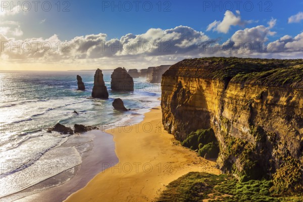 Powerful Pacific surf breaks down on the shore. Grandiose coast of Australia. Rocks of the Twelve Apostles at sunset. The concept of exotic, active and photo-tourism