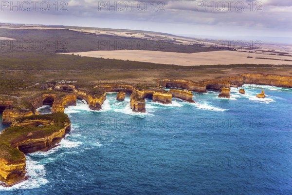 Scenic coastline. Picture taken from a helicopter. Port Campbell Park, Australia. Great Ocean Road and the Twelve Apostles is a group of limestone cliffs. The concept of extreme, active and photo tourism