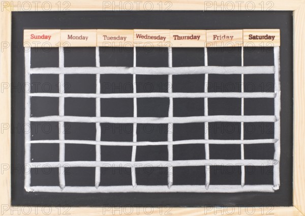 Monthly calendar with week words print on wood on blackboard