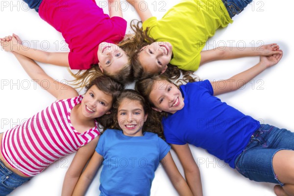 Happy kid friend girls group smiling aerial view lying on circle over white background holding hands