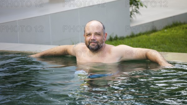 An image of a man relaxing in the pool