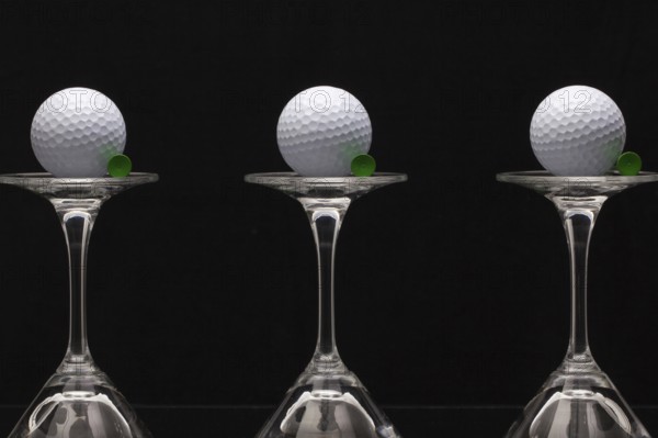 Three glasses of champagne with golf balls