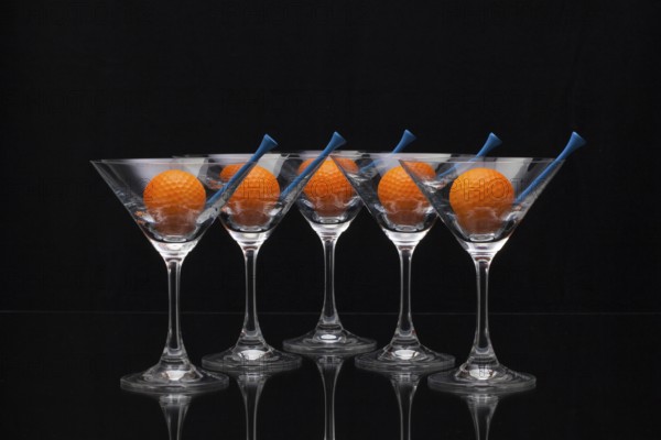 Five glasses of champagne with golf balls
