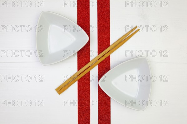 Ceramic bowls and bamboo chopsticks for sushi food with on the white wooden table.Top view. Flat Lay Image