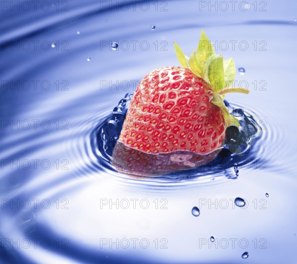 Blue water drop closeup with strawberry incide