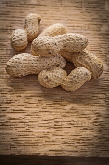 Small stack of peanuts on vintage wooden board food and drink concept