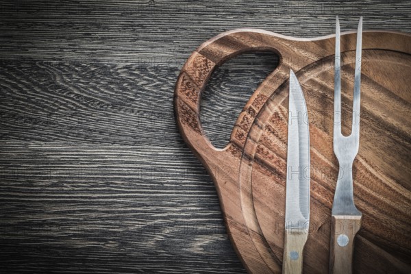 Meat fork knife chopping board on vintage wooden background