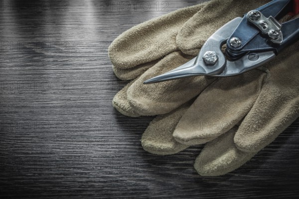 Safety gloves steel scissors on wooden board