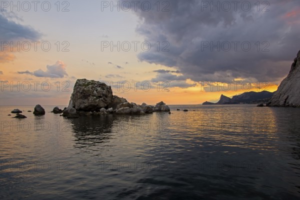 Sunset on the Black Sea coast. View from the embankment of Sudak in the direction of Novyy Svet. Crimea
