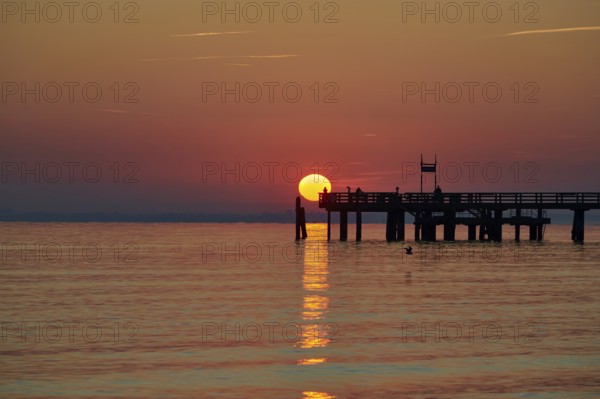 Red sunrise over the sea at the pier of the Baltic Sea resort, Boltenhagen, Mecklenburg-Vorpommern, Germany, Europe
