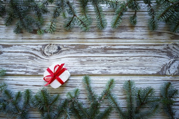 Fir branch christmas and gift on white wooden vintage background