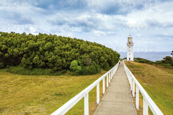 Magnificent lighthouse on the ocean shore. The Great Ocean Road runs along the Pacific coast of Australia. The path to the lighthouse