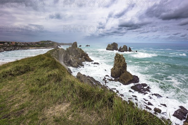 Dramatic stormy sky. Windy stormy day on the Atlantic coast. Surf waves with a foam crest. Cantabria Beaches, Portio Beach. Noon on the beach of Playa di Arnia, Spain, Europe
