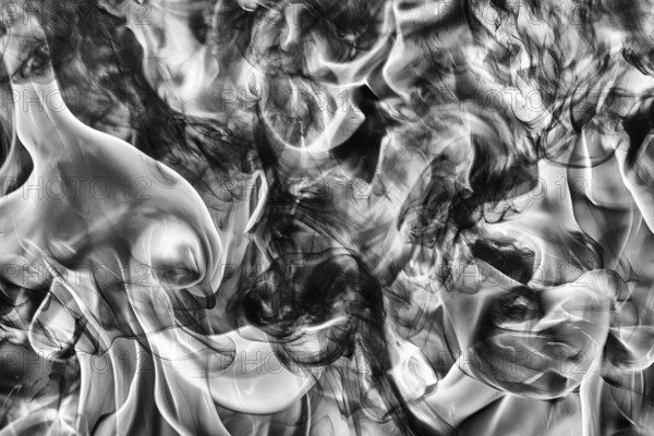 Abstract black smoke natural black smoke and white huge flame of strong fire. Dangerous firestorm abstract texture. Motion blur from fire, high temperature from flames. Dramatic black and white image