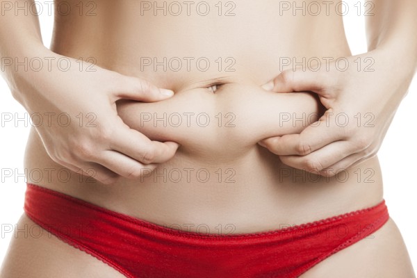 Overweight woman hand holding or pinching fat body belly paunch