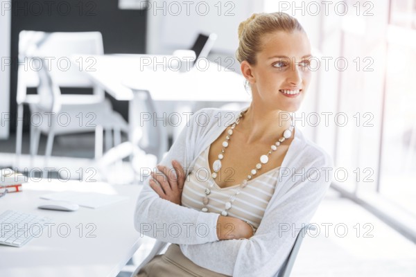 Attractive young woman sitting at desk and working on her computer