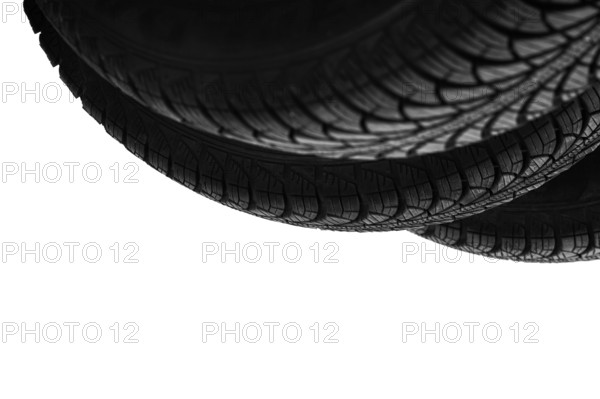 Isolated on white, three bottoms of new black rubber automobile tires with protector