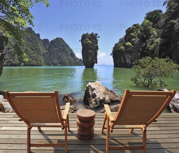 The most beautiful landscape in the world. The island in the form of a green vase in the sea gulf with clear emerald water. Two wooden chairs - on a wooden platform. The comfortable place to enjoy the beauty of the landscape