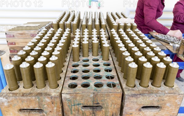 RPG explosive elements of anti tank rocket-propelled grenades (RPGs, bazooka) near an assembly line in a munition factory. Working in dangerous conditions