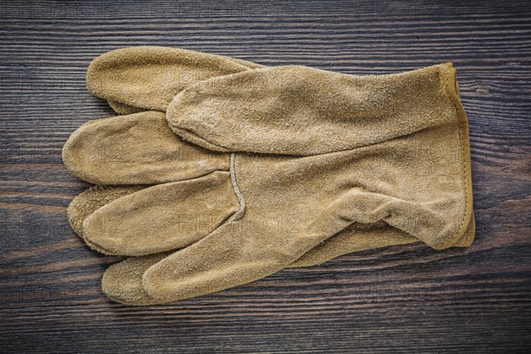 Pair of working gloves on vintage wooden board directly above agriculture concept