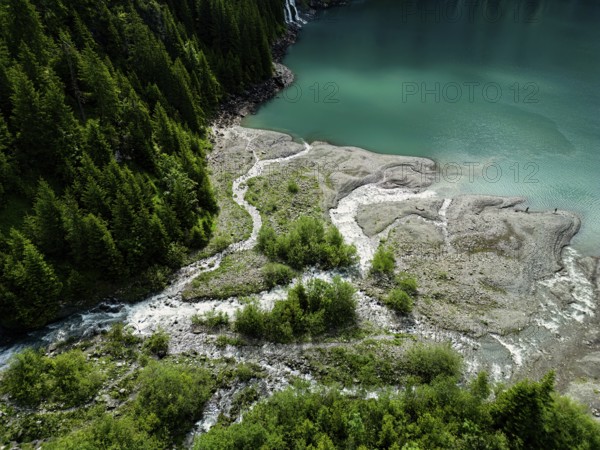 Top view of a forested landscape with winding streams leading to a lake, nature, water, ice, glacial streams, mountain lake, lake, Oeschinensee, Lake Oeschinen above Kandersteg, Swiss Alps, Switzerland, Europe