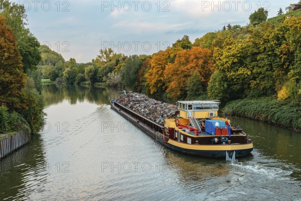 Transportation industry. Ship barge transports scrap metal and sand with gravel. Barge loaded with scrap metal is on the roadstead. Scrap metal transportation by water. Barge laden by metal salvage. Ship with scrap metal. Stuttgart, Ludwigsburg, Marbach am Neckar, Freiberg am Neckar, Germany, Baden Wurttemberg, Europe