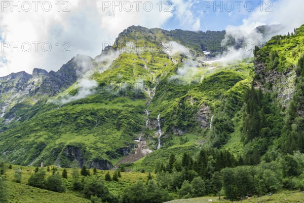 Imposing green mountains with waterfalls and clouds, offering a majestic view of nature, mittersill, hohe tauern, austria