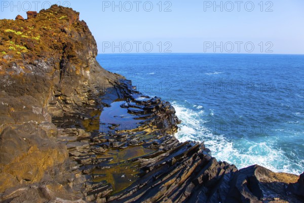 Small bay with azure water. Volcanic island of Madeira. Grottoes and rocks of the Atlantic coast. The concept of ecological and exotic tourism