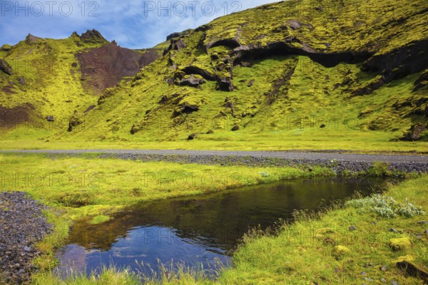 Picturesque basalt hills overgrown green grass and moss. On bottom of canyon many streams flow. Canyon Pakgil in Iceland