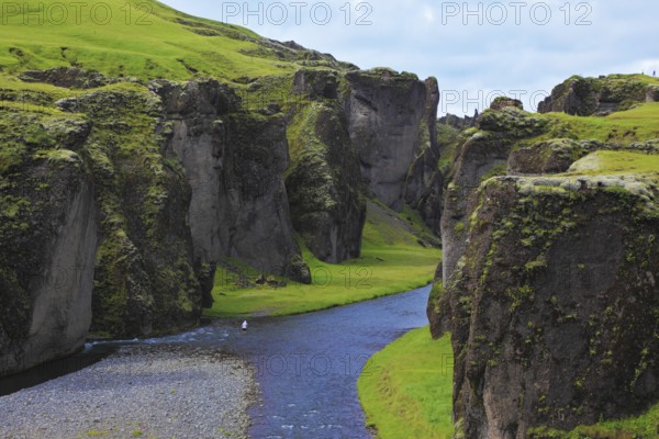 Iceland in the summer. Canyon Fjadrargljufur and cold fast river with a pebble bottom