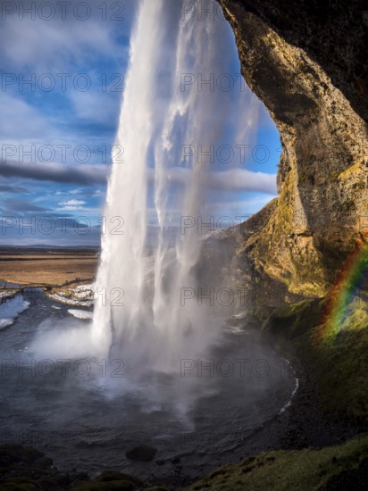 Seljalandsfoss, a majestic and powerful waterfall in Iceland in a sunny spring day with a raibow