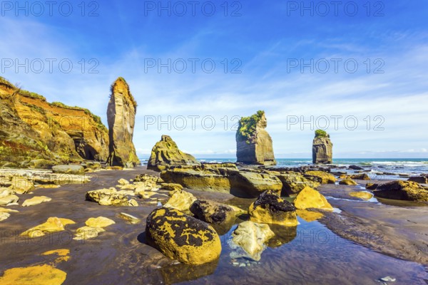 Picturesque rocks Three Sisters on the Pacific coast. The concept of active and phototourism. New Zealand, North Island