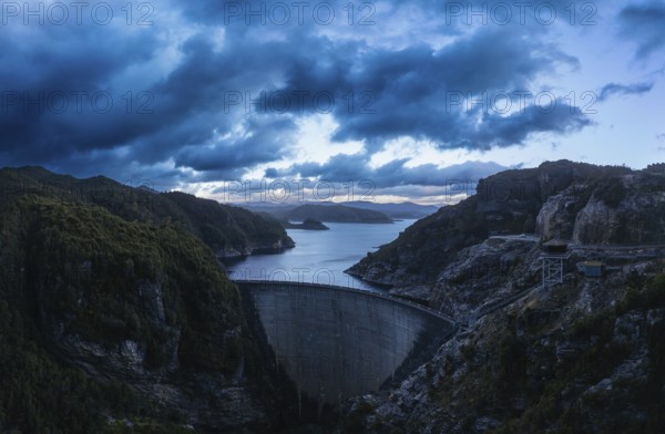 An aerial view of the Gordon Dam on a cool summer's day. It is a unique double curvature concrete arch dam with a spillway across the Gordon River near Strathgordon, South West Tasmania, Australia, Oceania