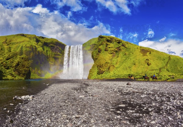 Huge waterfall flowing from under giant glacier. Iceland, waterfall Skogafoss summer, clouds of mist