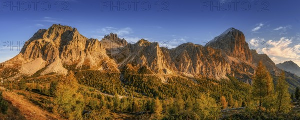 Lagazuoi mountain in the light of the setting sun near Passo Falzarego Autumn colors of the Dolomite massifs with yellow larch