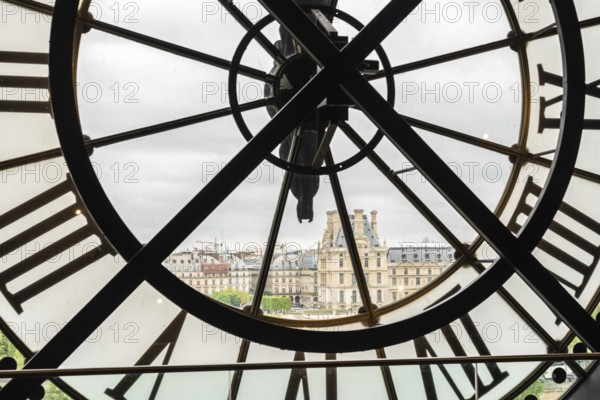 View of the Louvre through a large Clock from Museum d'Orsay in Paris, France, Europe