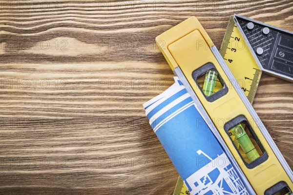 Blue construction plan level square ruler on wooden board