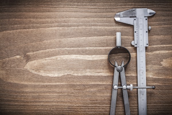 Slide caliper divider on wooden board copyspace construction concept