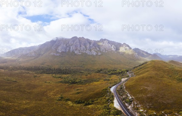 An aerial view of Gordon River Rd at the Sentinel range of mountains near Bitumen Bones Sculpture on a hot summer's afternoon in Southwest National Park, Tasmania, Australia, Oceania