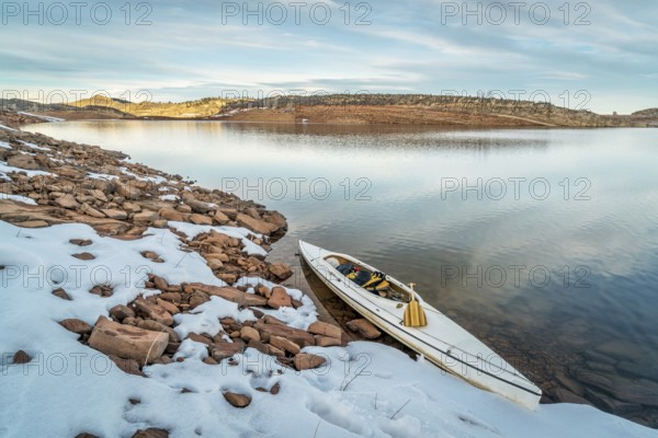 Decked expedition canoe on a shore of Horsetooth Reservoir near Fort Collins in northern Colorado, winter scenery with some snow