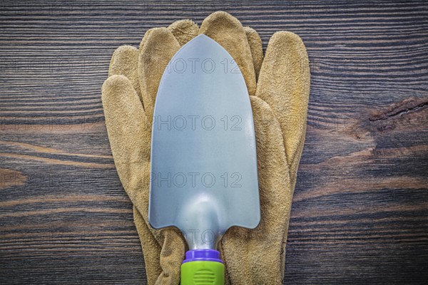 Hand spade protective gloves on wooden board agriculture concept