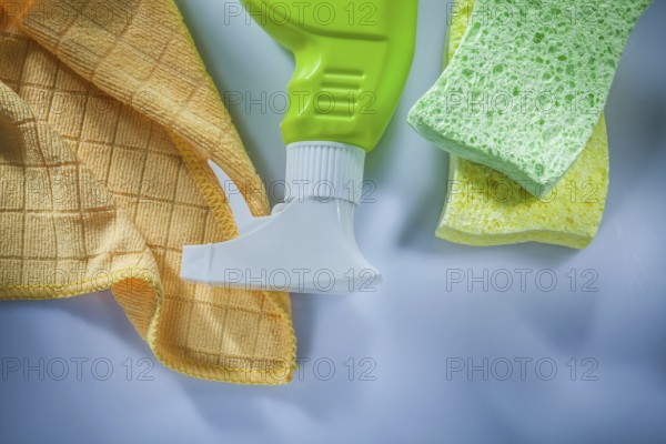 Plastic sprayer washing sponge cloth on white surface